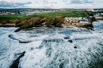 Cliffed coast with bathing cabins seen from the sea on a windy day.